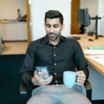 Man in Black Dress Shirt Holding Blue Ceramic Mug