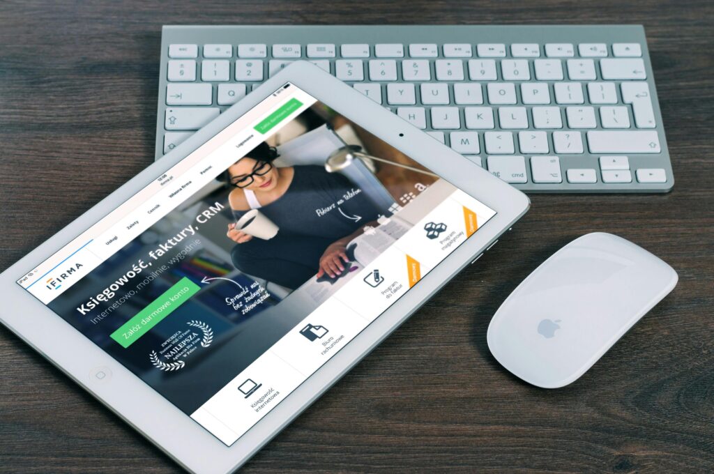 A tablet with a financial website open, alongside a white keyboard and mouse. Ideal for tech-theme stock images.